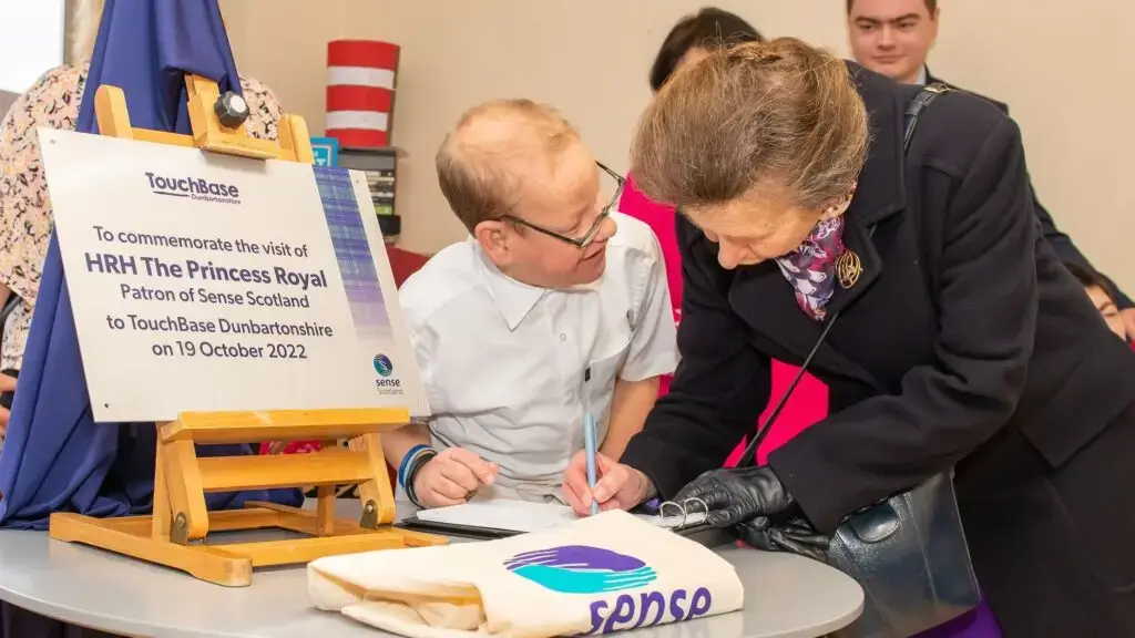 HRH The Princess Royal writing in a sign-in book at TouchBase Dunbartonshire