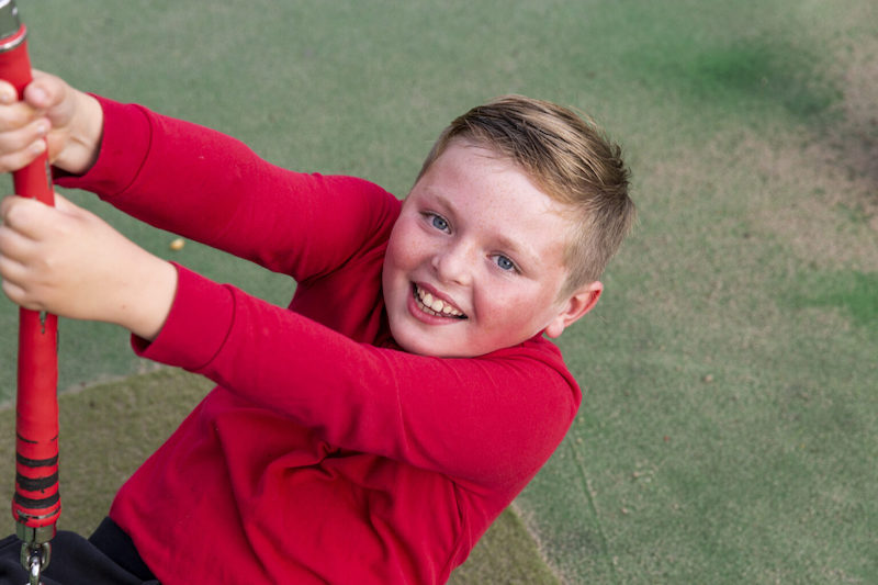 Jack playing on swing in outdoor park
