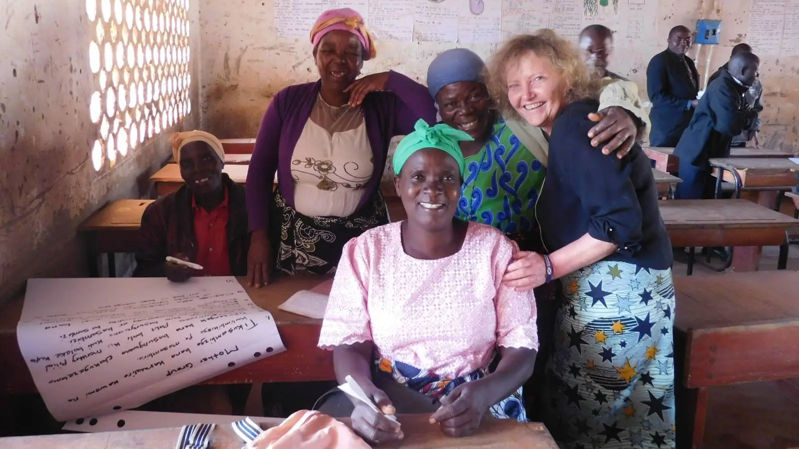 A representative from Sense Scotland warmly embracing several Malawian women.