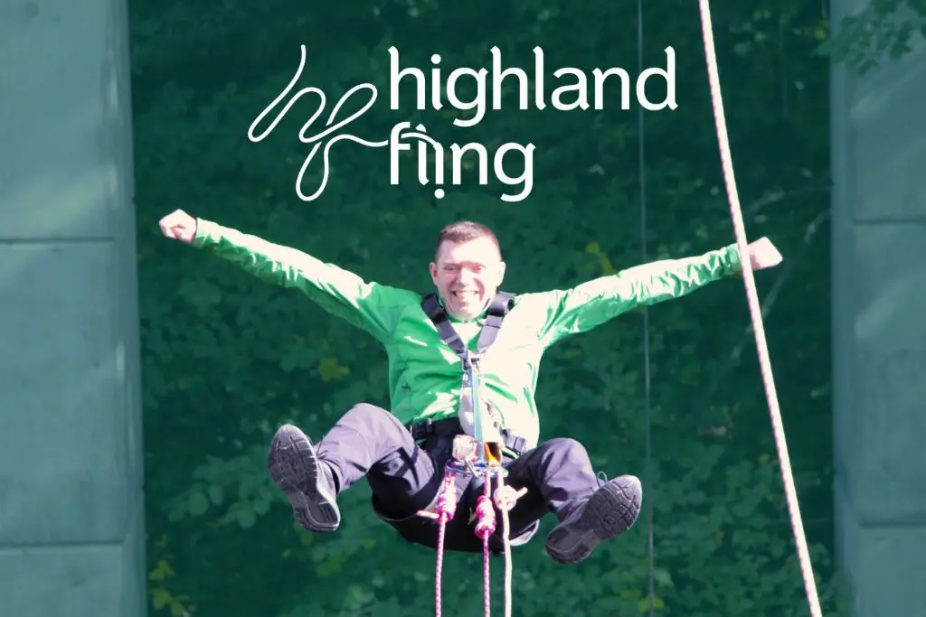 a man grinning in mid-air with his arms outstretched